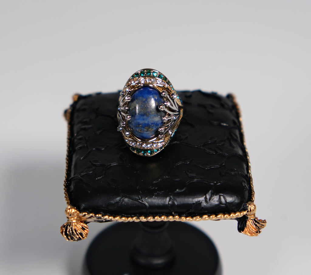 Gold-tone cocktail ring with deep blue centre stone, top-down view – Ceroundmi