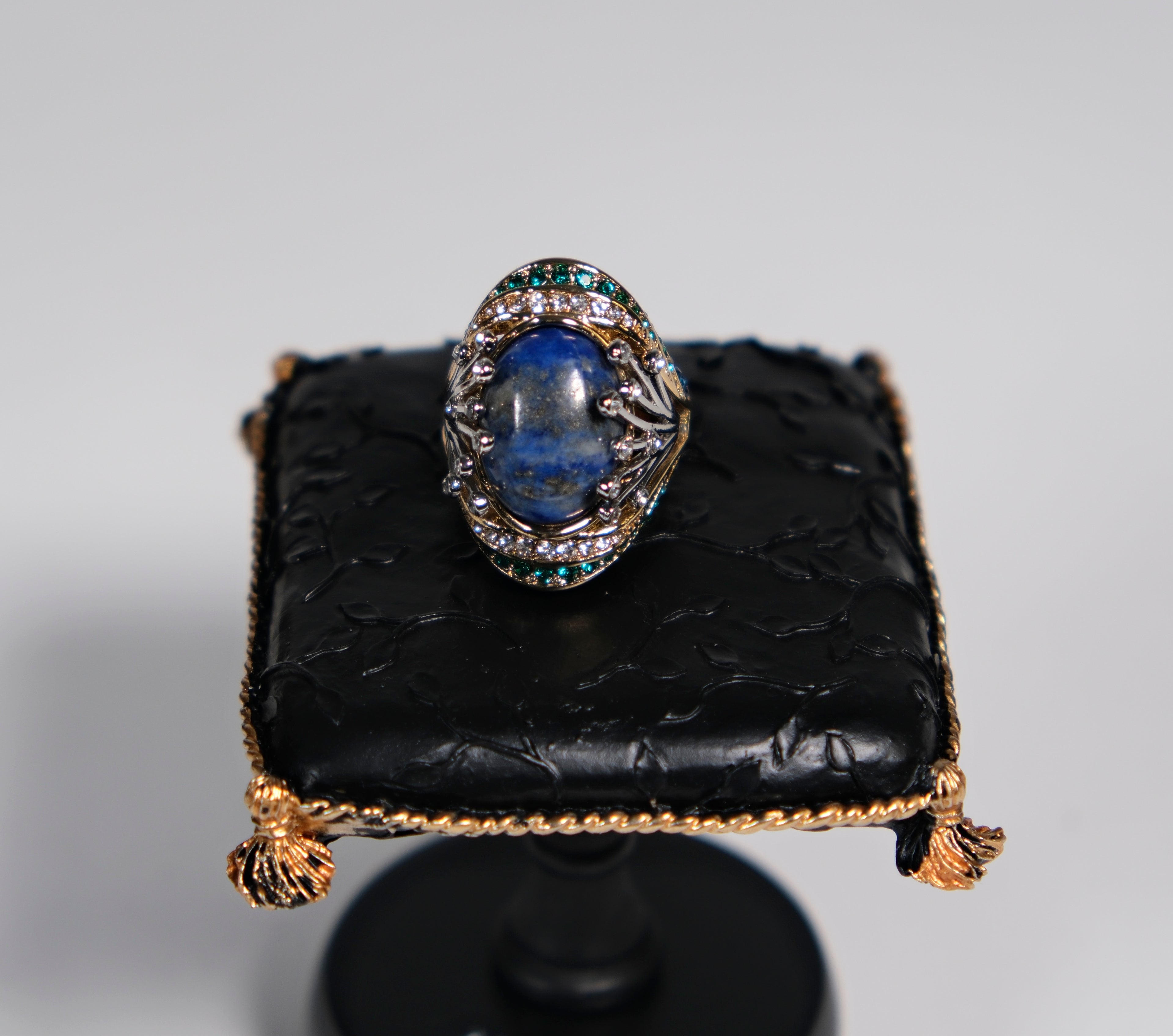 Gold-tone cocktail ring with deep blue centre stone, top-down view – Ceroundmi