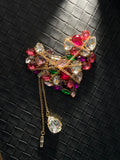 Vintage-inspired heart brooch with multicoloured crystal embellishment, gold chain overlay and dangling crystal tassels.